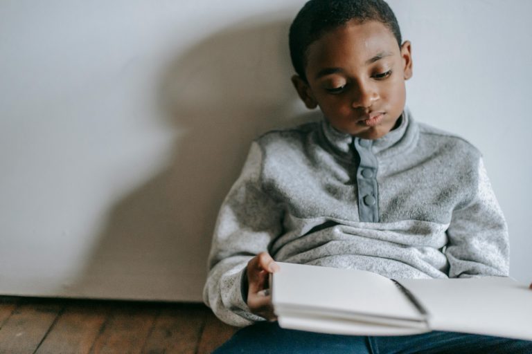 Young boy frustrated while reading a book